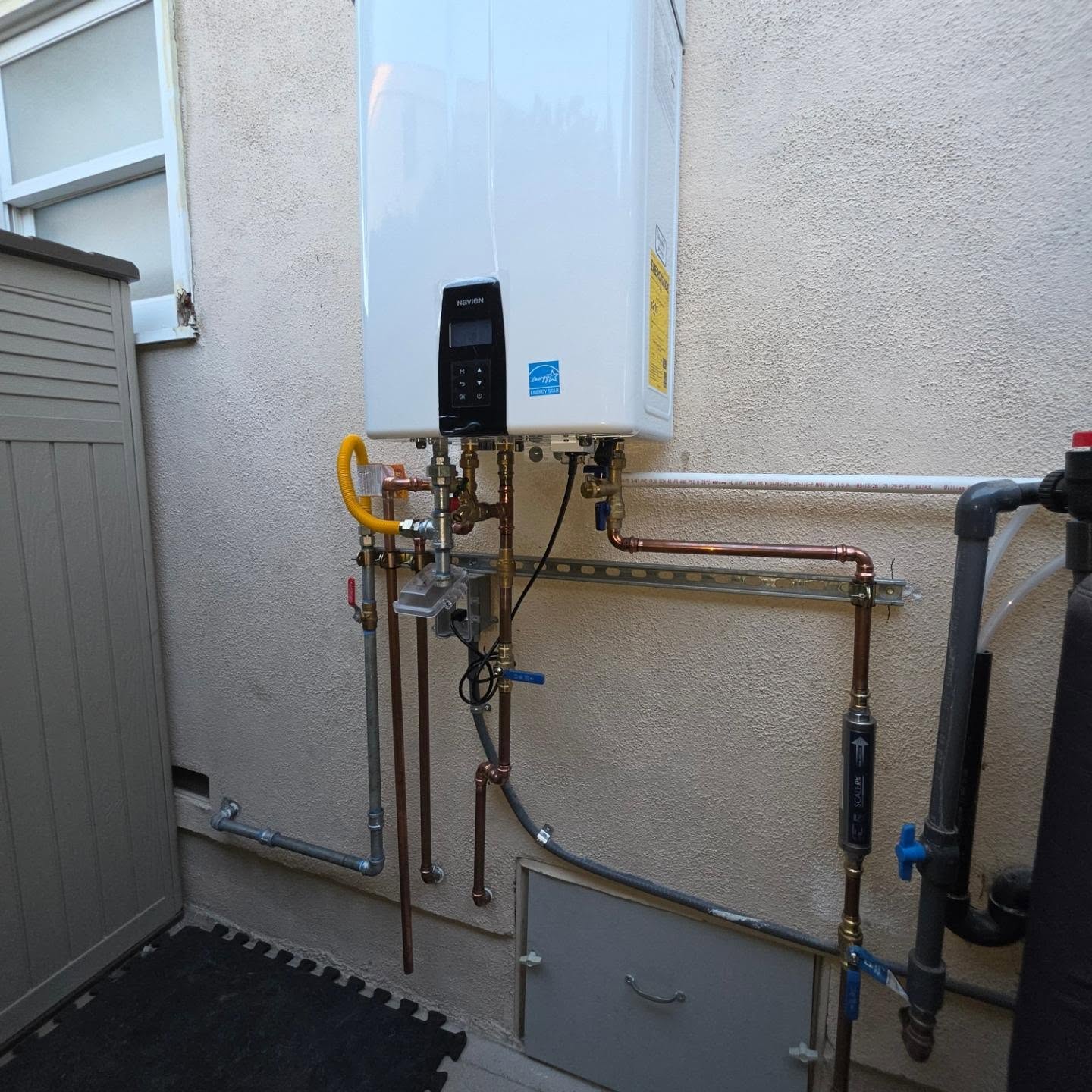 Copper lines and service valves below an outdoor tankless unit